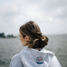 Load image into Gallery viewer, Sunset design detail on hood of grey sweatshirt.  Great Lakes scenery in the background.